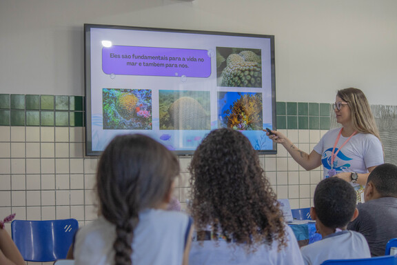 Educadora apresenta a importância dos corais para estudantes em sala de aula