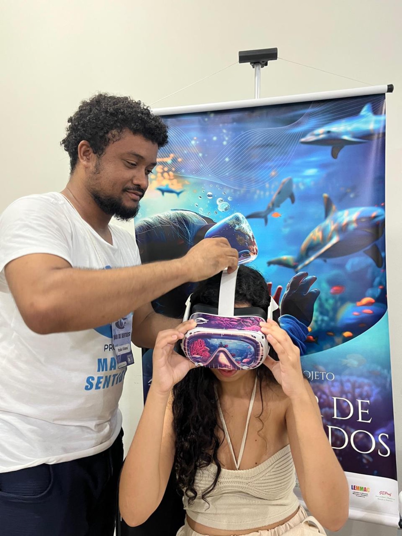 Integrante da equipe ajusta óculos de realidade virtual em uma participante