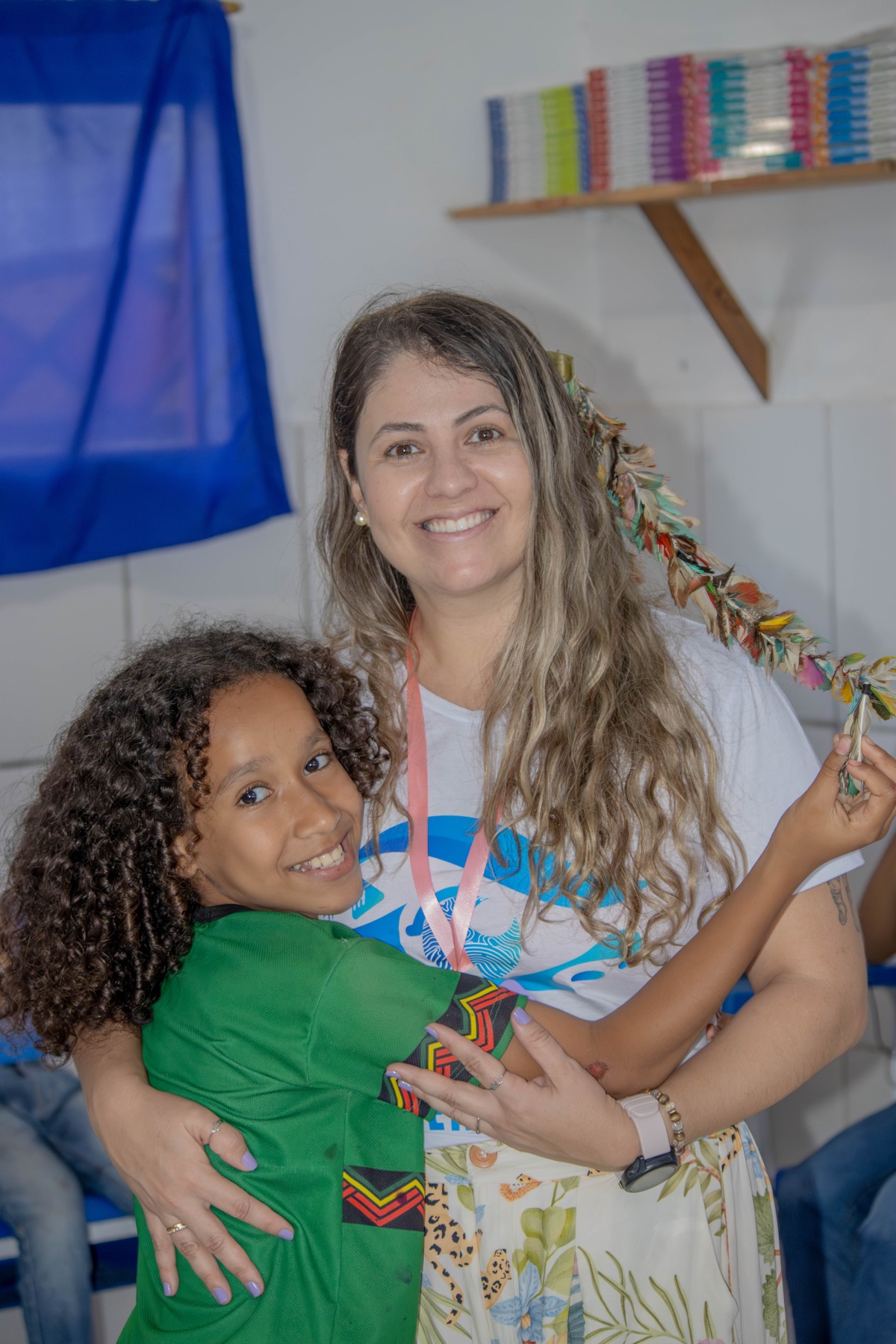 Educadora e estudante sorriem juntas durante uma atividade do projeto