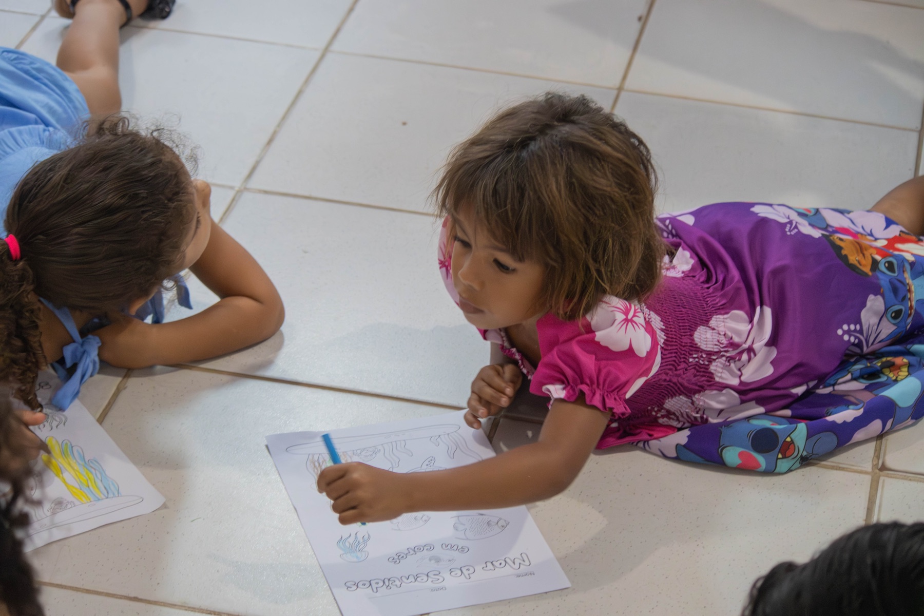 Crianças desenham e pintam a vida marinha durante uma atividade em grupo