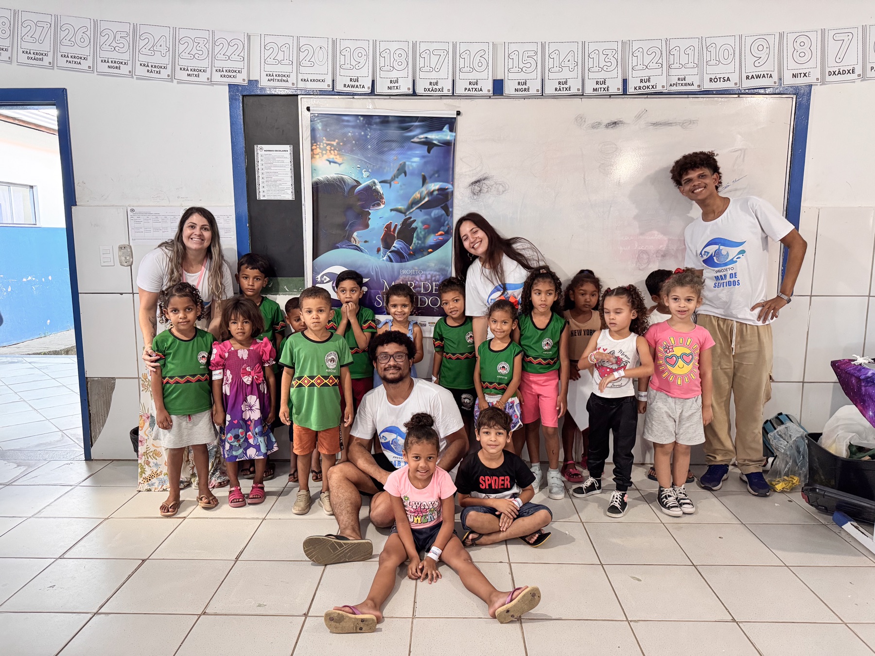 Equipe do Projeto Mar de Sentidos posa com uma turma de crianças após a atividade
