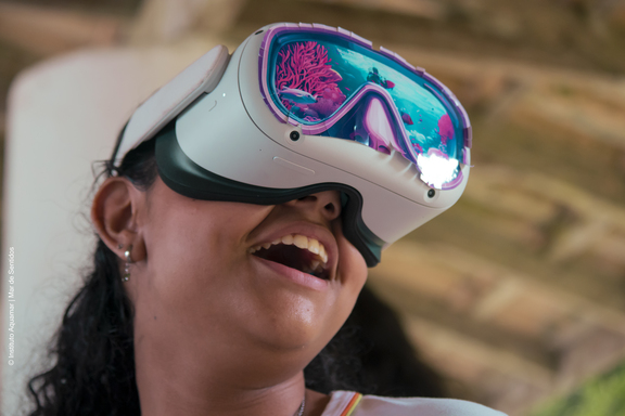 Jovem sorri durante uma experiência de realidade virtual sobre o oceano